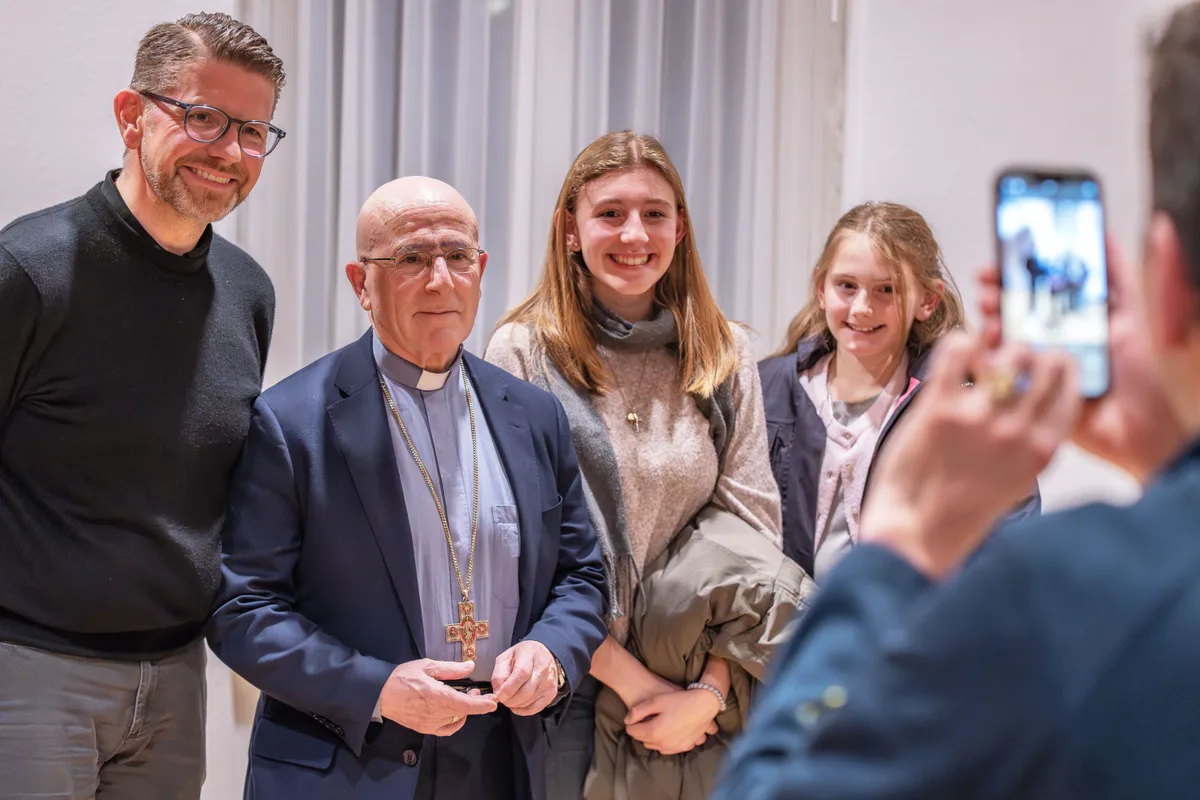 Mittendrin: Einige der Anwesenden liessen sich mit Bischof Joseph Maria Bonnemain fotografieren. Man sieht Bischof Bonnemain mit einer Familie beim Fotografiertwerden.